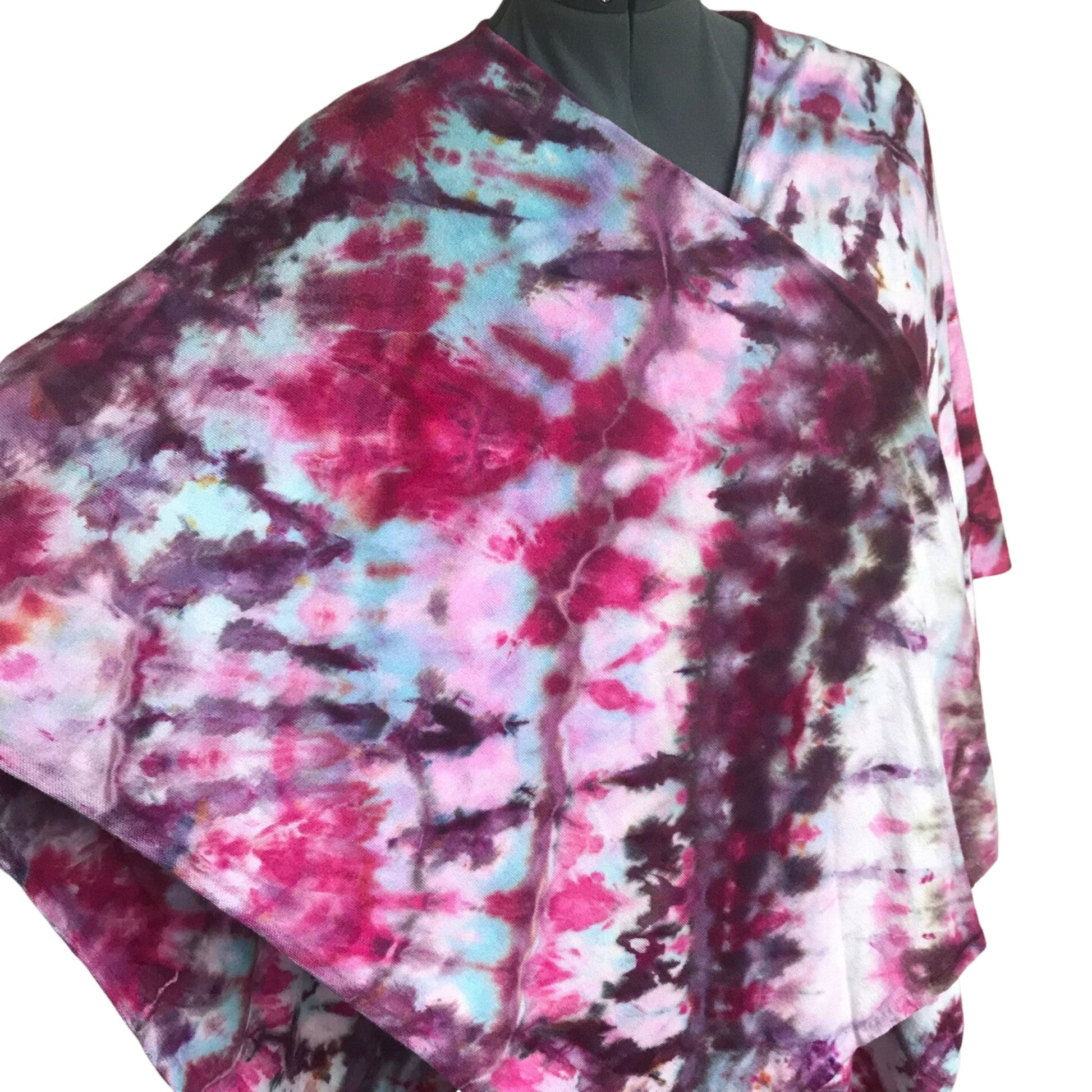 Front View of a Tie Dye Shawl wrapped around a dressform. One side is extended out as if over an arm. The colors are turuoise and magenta in abstract irregular lines